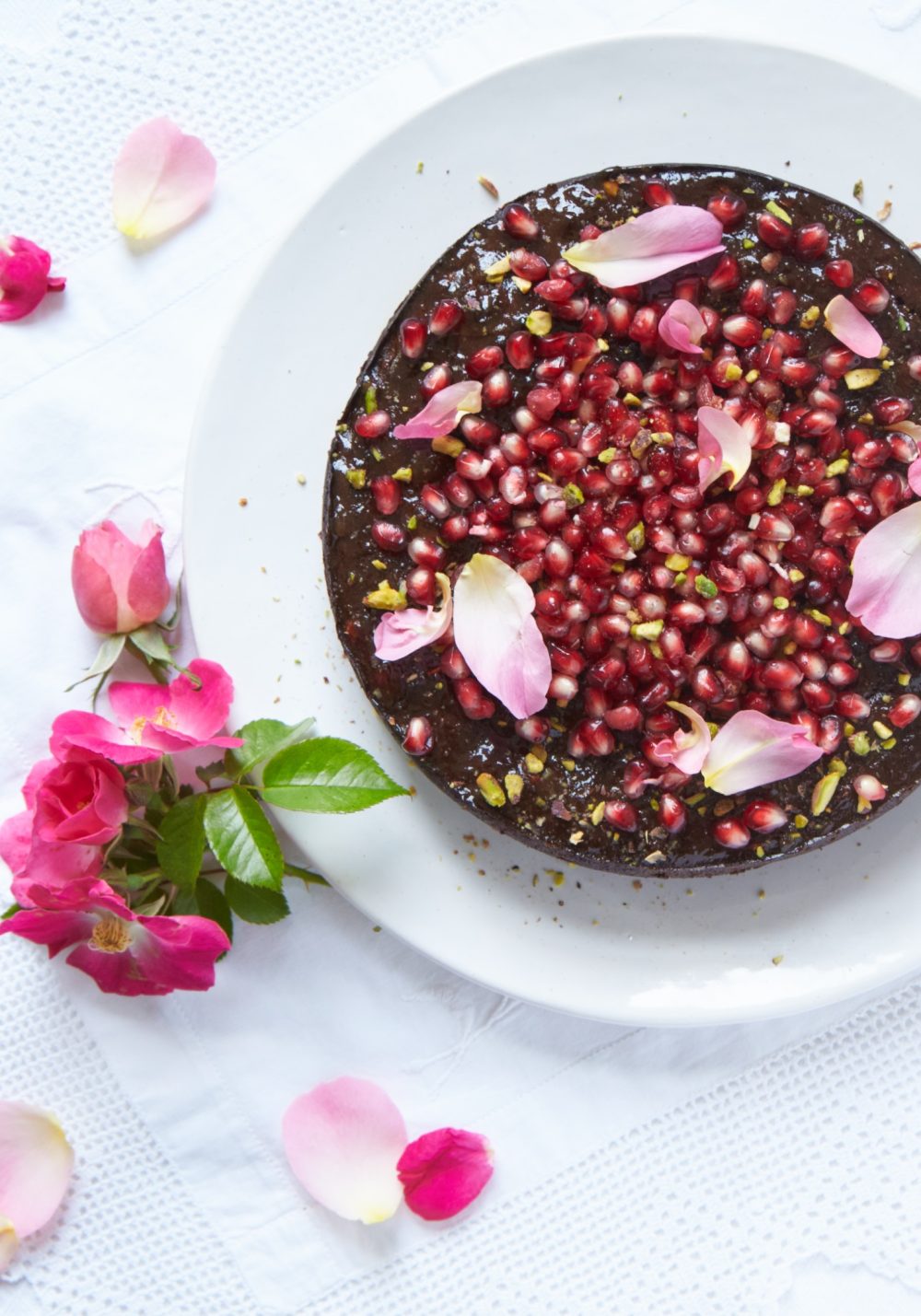 Chocolate and pomegranate cake with rose petals
